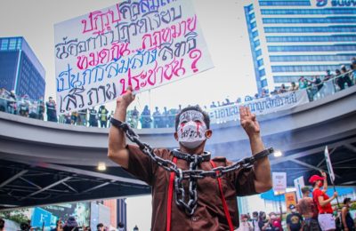 Seorang demonstran merantai dirinya dalam aksi unjuk rasa di Bangkok pada 14 November 2021, di mana massa berkumpul untuk menyerukan reformasi monarki di Thailand. (Foto: VOA/Tommy Walker)