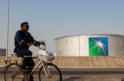 Seorang karyawan mengendarai sepeda melewati tangki minyak di fasilitas minyak Saudi Aramco di Abqaiq, Arab Saudi. (Foto: Reuters)