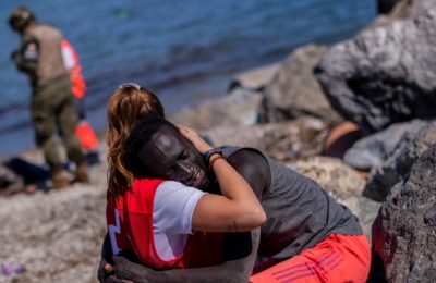 Seorang petugas Palang Merah Spanyol tampak berusaha menenangkan seorang migran di wilayah Ceuta di perbatasan antara Maroko dan Spanyol. (Foto: AP/Bernat Armangue)