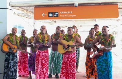 Para tamu disambut dengan penampilan tradisional Fiji saat mereka tiba di bandara internasional Nadi, Fiji, 1 Desember 2021. (Bruce Rounds/Tourism Fiji via AP)