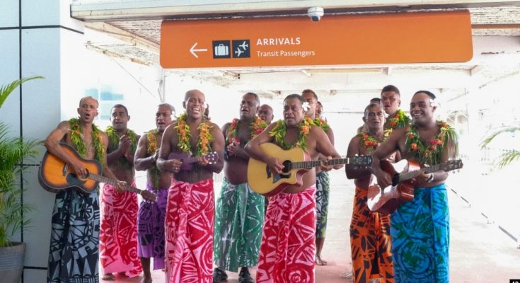 Para tamu disambut dengan penampilan tradisional Fiji saat mereka tiba di bandara internasional Nadi, Fiji, 1 Desember 2021. (Bruce Rounds/Tourism Fiji via AP)