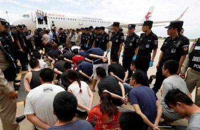 Warga negara Taiwan dan China yang diduga melakukan penipuan telekomunikasi dikelilingi oleh tim SWAT polisi China dan polisi Kamboja saat mereka dideportasi ke China di Bandara Internasional Phnom Penh, 24 Juni 2016. (REUTERS/Samrang Pring)