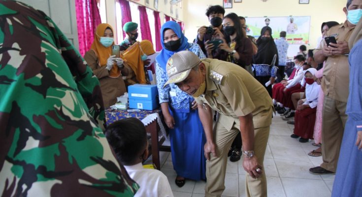 Plt Bupati Penajam Paser Utara, Hamdam Pangrewa menyapa siswa sekolah dasar dalam kegiatan vaksinasi usia 6-11 tahun di daerah itu, Senin (17/01) (ESY)