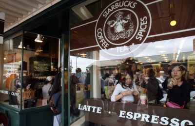 Turis Jepang menikmati kopi di kedai kopi pertama Starbucks di Pike Place Market Seattle, 30 September 2006. Gerai ini berdiri sejak 1971. (AFP PHOTO/GABRIEL BOUYS)