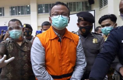 Menteri Kelautan dan Perikanan Edhy Prabowo (tengah) dikawal petugas keamanan usai konferensi pers di Komisi Pemberantasan Korupsi (KPK) di Jakarta, pada 26 November 2020. (Foto: AP)