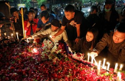 Suporter klub sepak bola Arema menyalakan lilin di luar stadion Kanjuruhan untuk menyampaikan belasungkawa kepada para korban pasca kerusuhan di Stadion Kanjuruhan, Malang, Jawa Timur, Minggu 2 Oktober 2022.