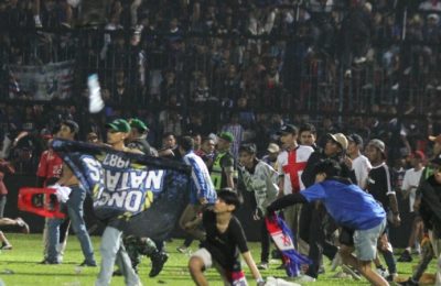 Suporter Arema FC memasuki lapangan setelah tim yang mereka dukung kalah dari Persebaya usai pertandingan liga BRI Liga 1 di Stadion Kanjuruhan, Malang, Provinsi Jawa Timur, 2 Oktober 2022. (Antara Foto/Ari Bowo Sucipto/via REUTERS)