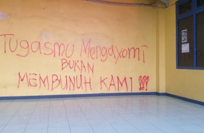 Bentuk protes suporter atas sikap represif aparat tertulis pada tembok stadion Kanjuruhan di Malang, Jawa Timur, pada 4 Oktober 2022. (Foto: VOA/Petrus Riski)