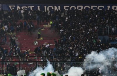 Petugas keamanan (bawah) mengamankan lapangan dengan menggunakan gas air mata usai pertandingan sepak bola antara Arema FC dan Persebaya Surabaya di Stadion Kanjuruhan, Malang, Jawa Timur. (Foto: AFP)