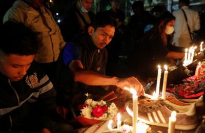 Suporter klub sepak bola "Arema" menyalakan lilin di luar stadion Kanjuruhan untuk menyampaikan belasungkawa bagi korban pasca kerusuhan di Stadion Kanjuruhan, Malang, Jawa Timur, Minggu 2 Oktober 2022.