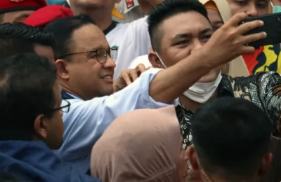 Anies Baswedan (tengah) melakukan swafoto dengan pendukungnya setelah dirinya resmi menyelesaikan tugasnya selama 5 tahun dari 2017 hingga 2022 sebagai gubernur DKI Jakarta pada 16 Oktober tahun ini. (VOA/Indra Yoga)