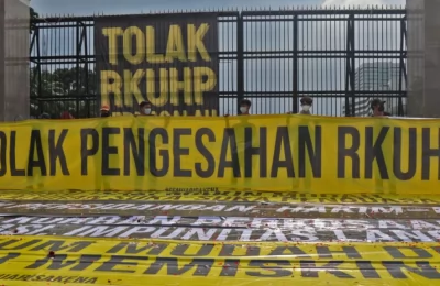 Sejumlah atribut spanduk dan poster terbentang di depan Gedung DPR pada Senin (5/12) siang yang isinya menolak pemerintah untuk mengesahkan RKUHP. (Foto: VOA/Indra Yoga)