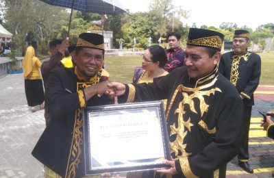 Bupati PPU, Hamdam menyerahkan penghargaan kepada Kepala DP3AP2KB Kabupaten PPU, Chairur Rozikin. (Ist)
