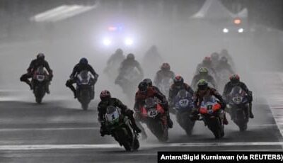 Pembalap mengendarai sepeda motor di tengah hujan lebat menjelang Race 2 Kejuaraan Dunia Superbike di Sirkuit Jalan Internasional Mandalika di Lombok, Nusa Tenggara Barat, 21 November 2021. (Foto: Antara/Sigid Kurniawan via REUTERS)
